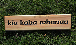 macrocarpa sign 500 x 140 "the orchard" with plants in the background