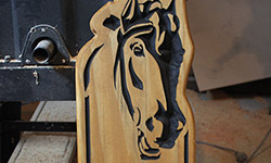 number carved into pine with horse head carved at top for horse farm